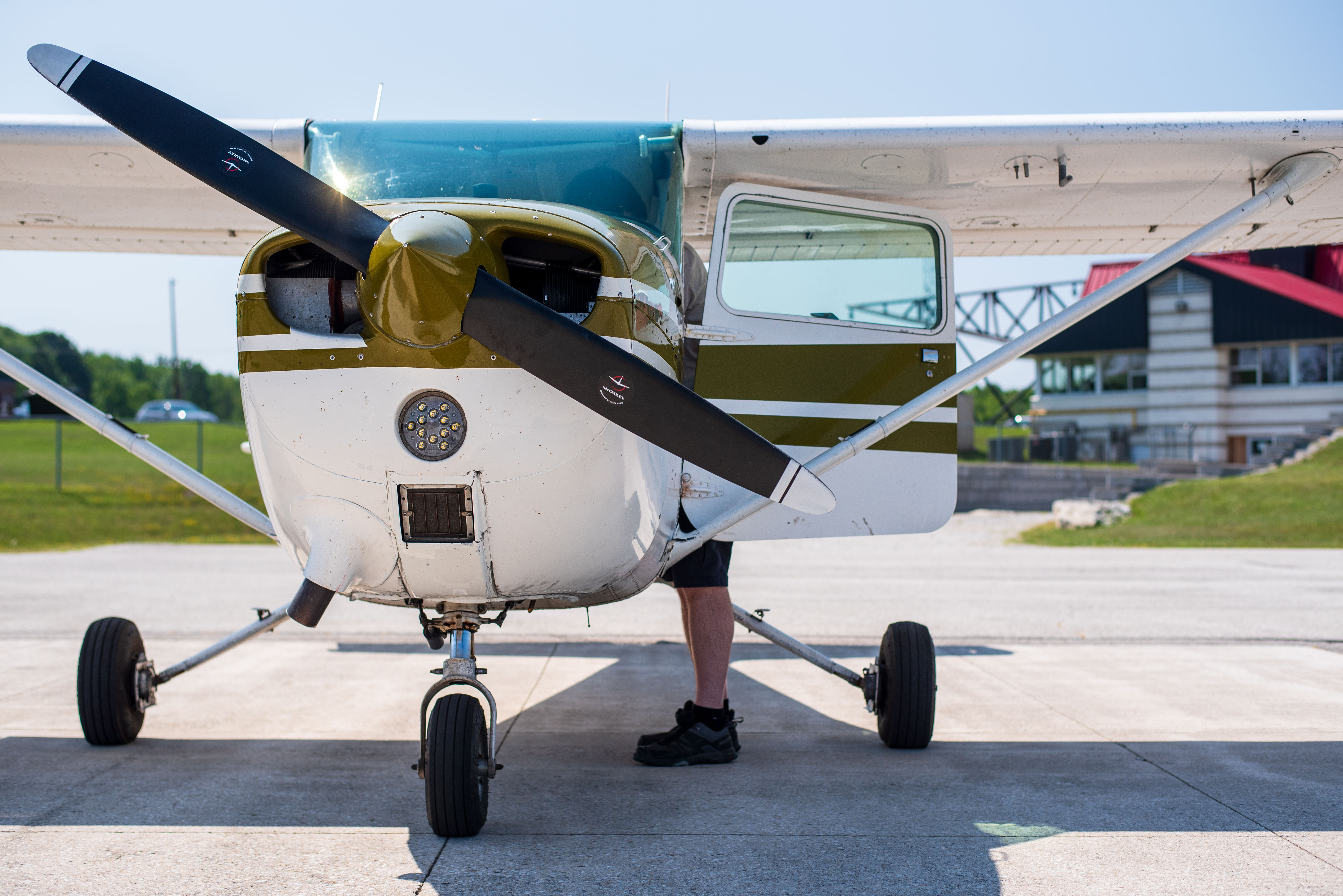 A single propeller aircraft, white with green accents, parked on tarmac.