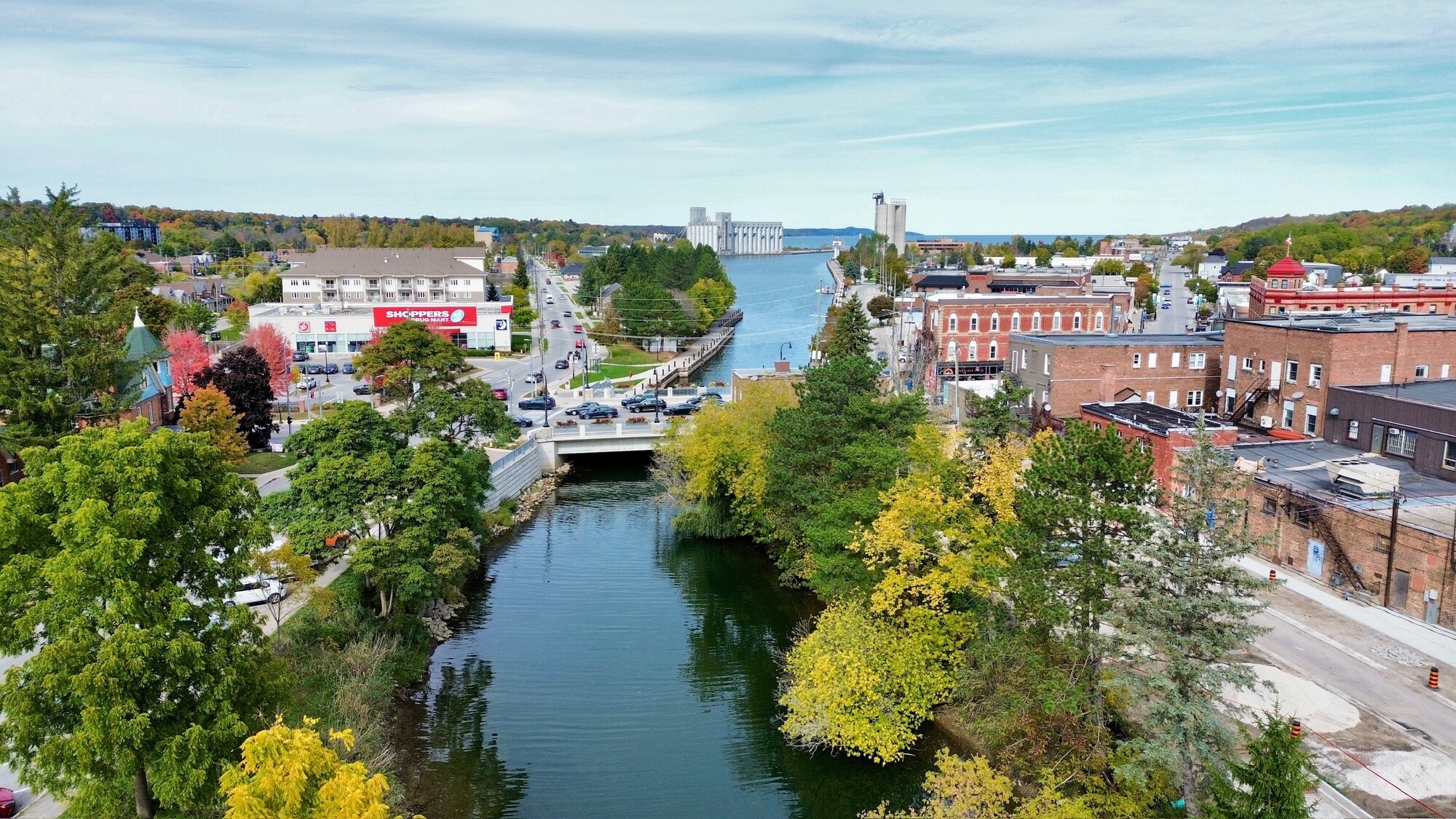 Aerial view of downtown Owen Sound. The Sydenham river, lined with trees, dominates the image.