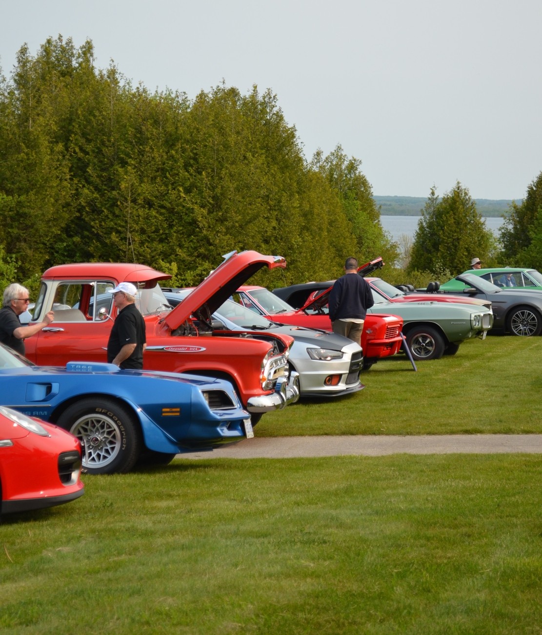 A lineup of vehicles at an outdoor car show.