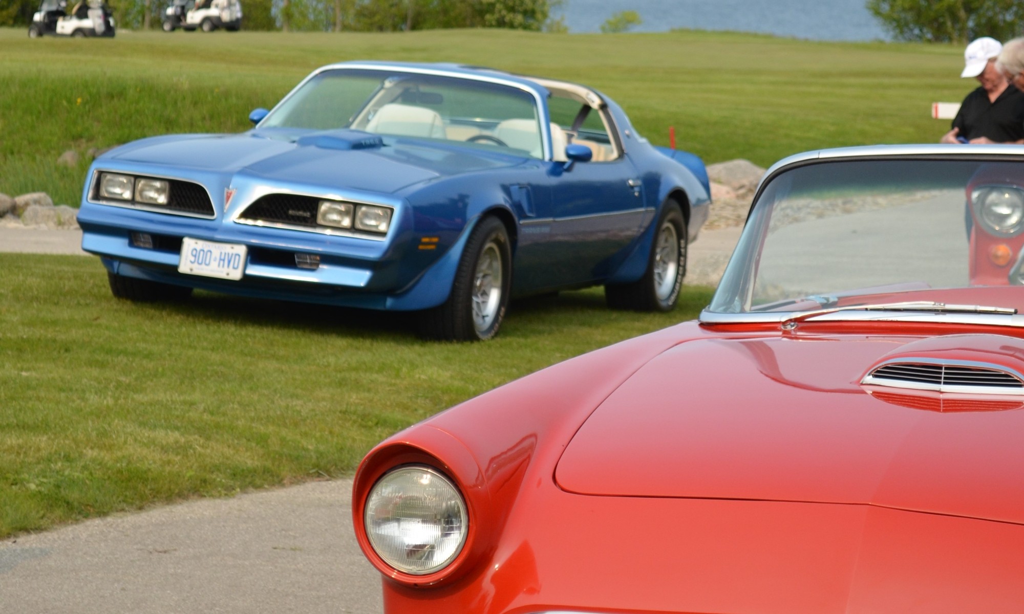 Two cars at an outdoor car show.