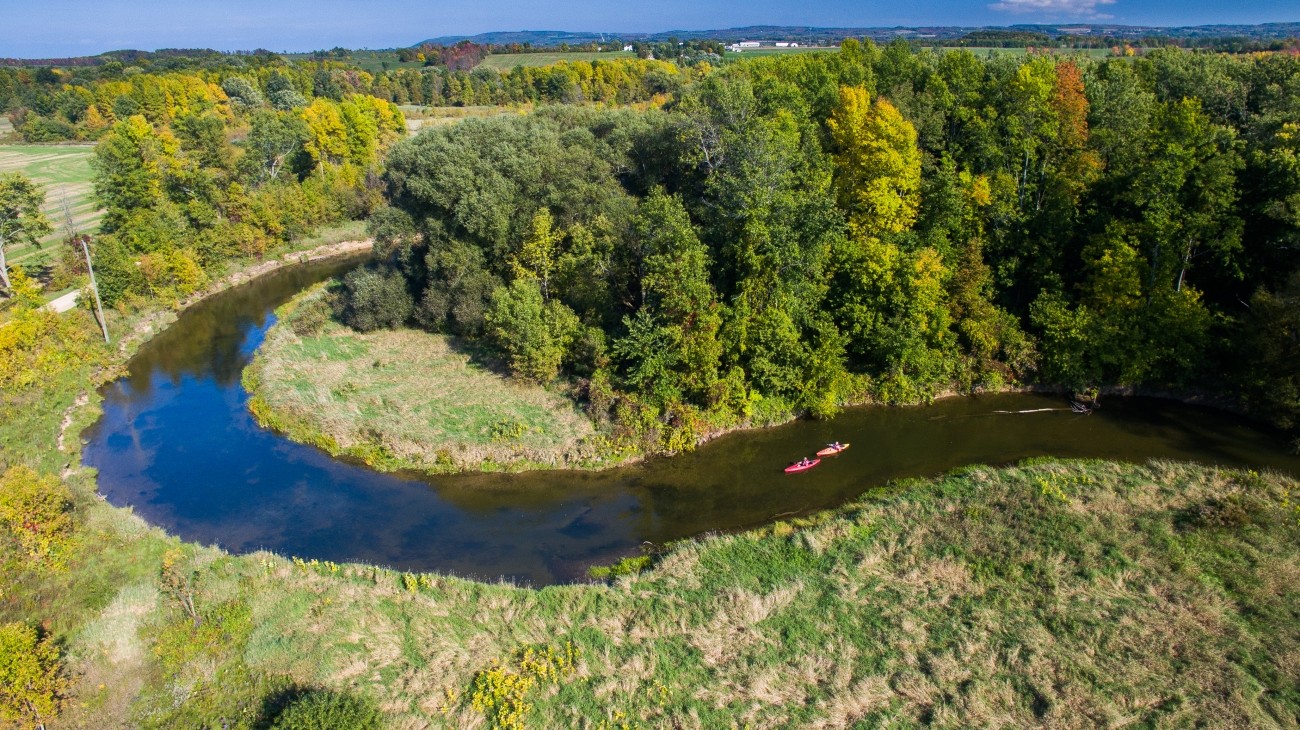 Aerial view of two kayakers on a meandering river.
