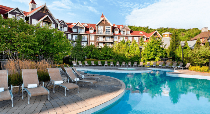 Lodges behind a pool and pool chairs