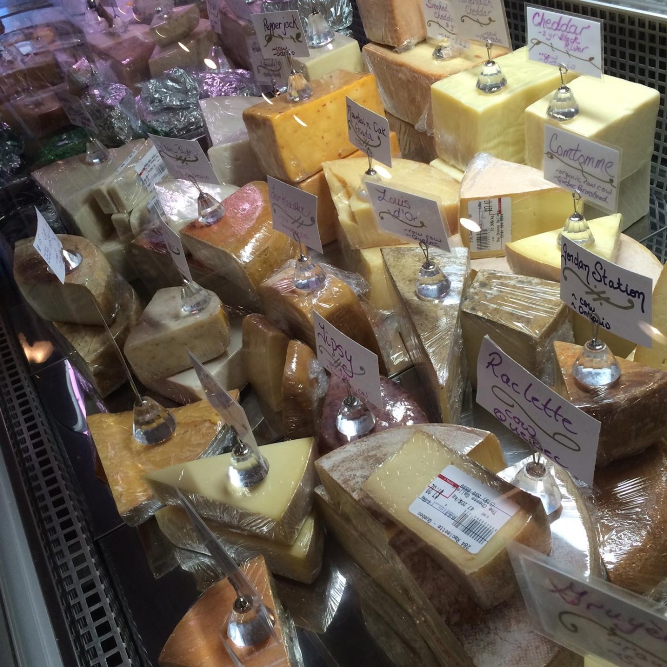 Many tyes of cheese on display with name cards.