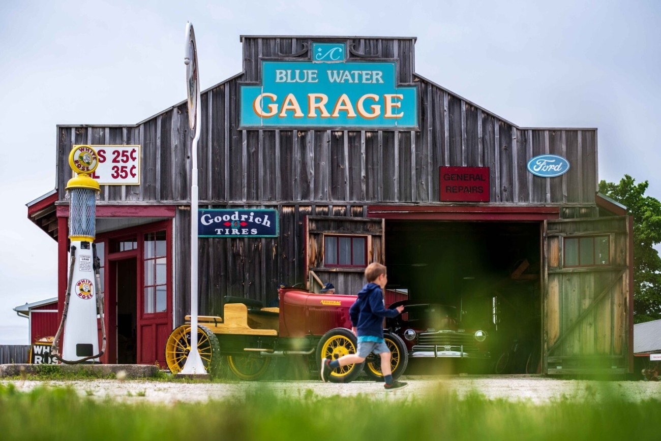 A child runs past a historic garage.