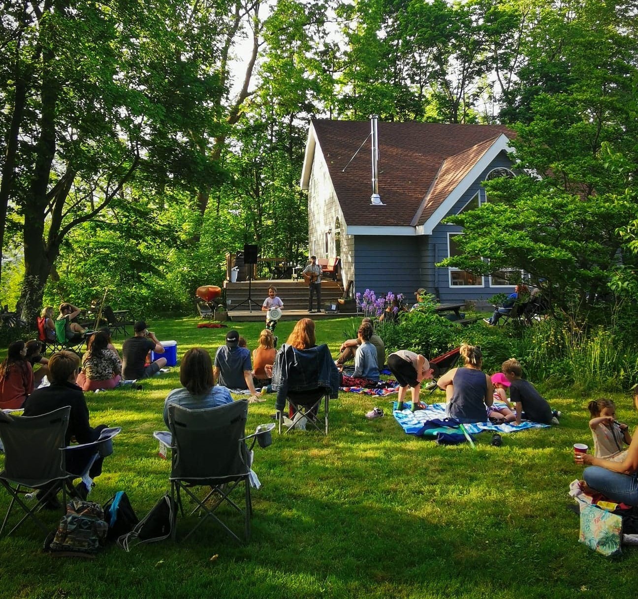 a crowd sitting outside enjoying live music
